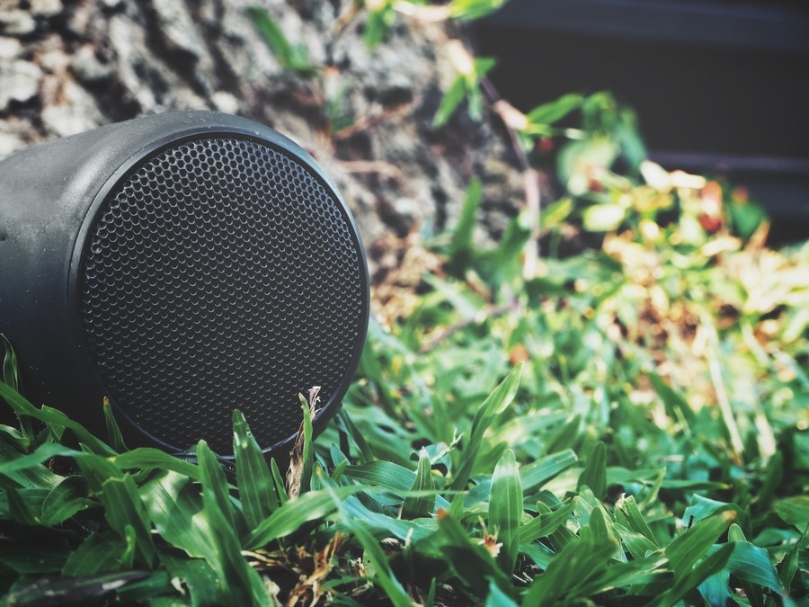 Close up on an outdoor speaker in grass. 