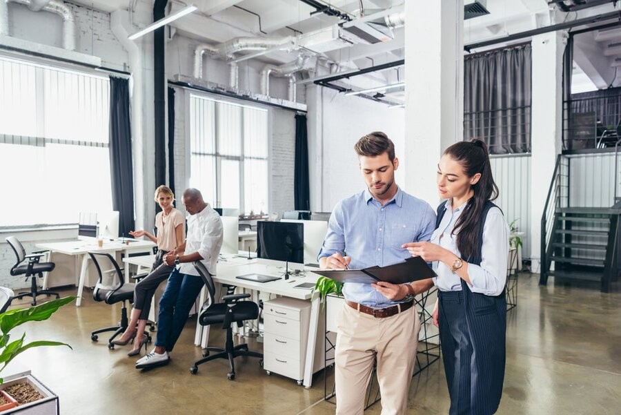 An open office space featuring employees using devices that utilize office networking solutions.