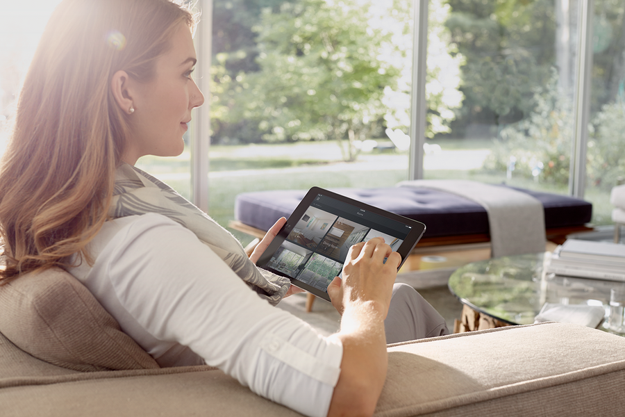 Woman using her phone to manage her Savant smart home automation system.