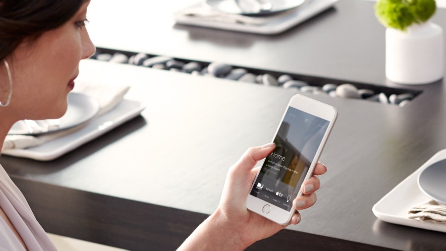 Woman using Savant smart home interface on a smartphone. 