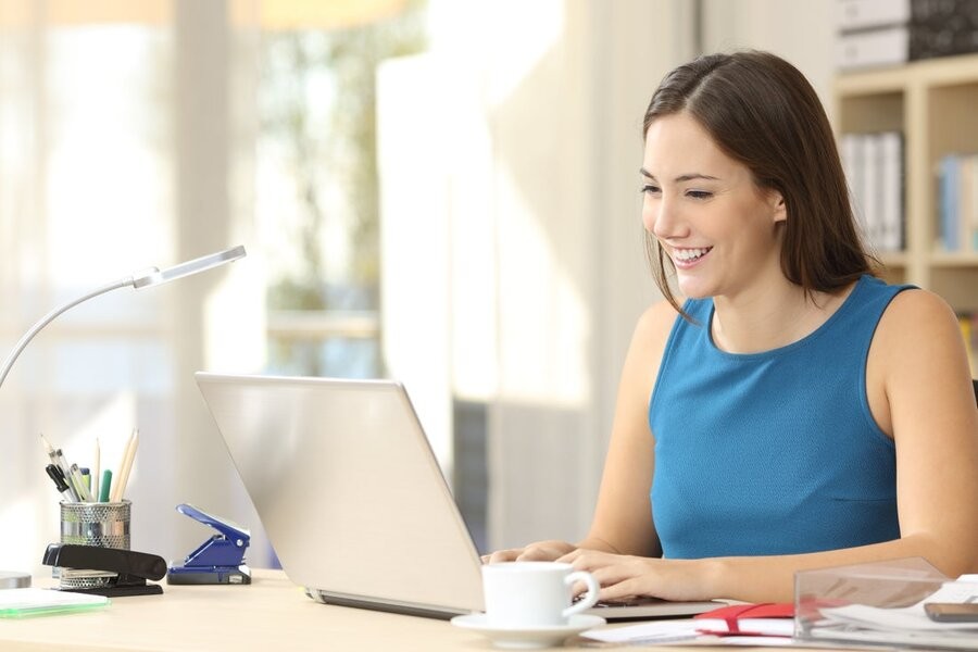 A woman in a home office using a laptop.