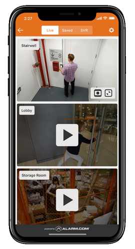 A mobile device displaying the Alarm.com app’s live video monitoring feature, highlighting security camera feeds for a business.