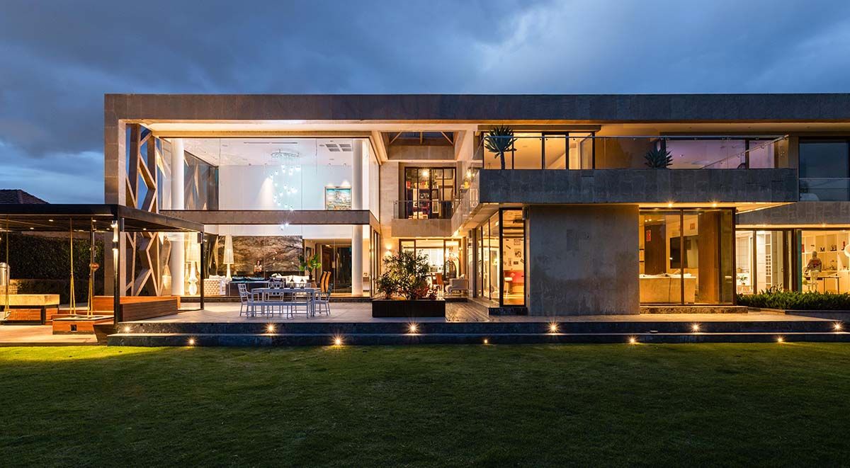 A modern, well-lit luxury home at dusk showcasing Alarm.com’s automated lighting and security systems for enhanced safety.