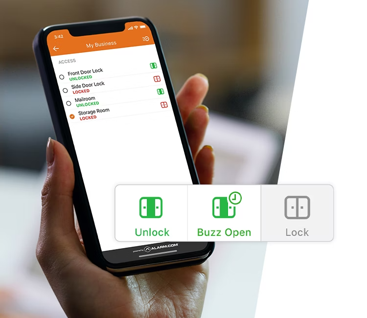 A hand holding a smartphone displaying Alarm.com’s business lock control interface, featuring options to unlock, lock, or buzz open secure doors remotely.